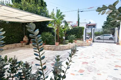 a patio with a bunch of plants and an umbrella at From Flori in Terrasini