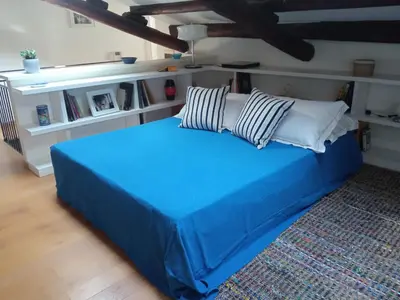 a blue bed with pillows on it in a room at Adenzia Suite in Palermo
