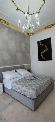 a bedroom with a bed and a chandelier at Casa Vacanza Marion in Palermo