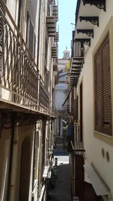 an alley with buildings and balconies in a city at Quattro Canti Valù in Palermo