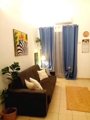 a living room with a brown couch and blue curtains at Quattro Canti Valù in Palermo