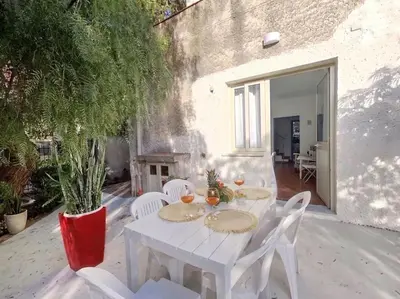 a white table and chairs on a patio at Holiday Home Green Paradise in Palermo