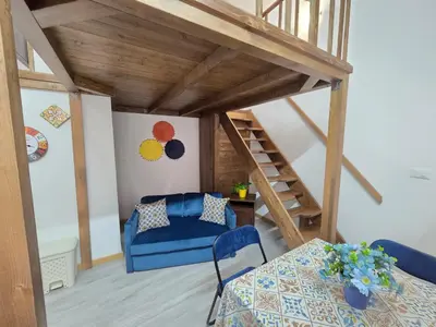 a living room with a blue couch and stairs at La casetta di John in Palermo