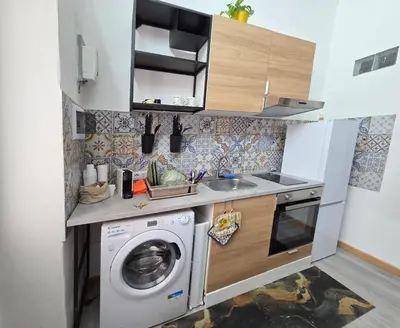 a small kitchen with a washing machine and a sink at La casetta di John in Palermo