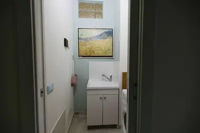 a bathroom with a sink and a painting on the wall at Nest - Family House in Santa Flavia