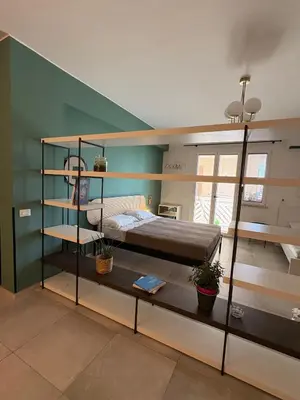 a room with two bunk beds and a green wall at Nest - Family House in Santa Flavia