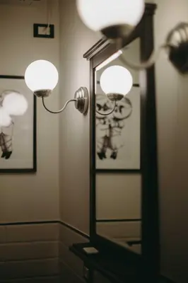a bathroom with two lights and a mirror at Nest - Family House in Santa Flavia