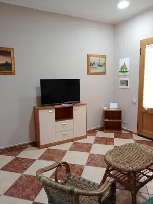 a living room with a tv and a table and chairs at Franci Zisa House in Palermo