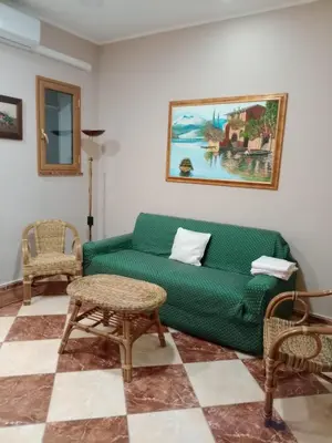 a living room with a green couch and chairs at Franci Zisa House in Palermo