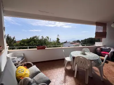 a living room with a table and chairs on a balcony at Orizzonte d'acqua Palermo in Palermo