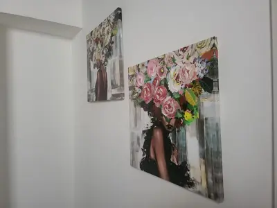 two paintings of a woman with flowers on a wall at La loggia Apartment in Palermo