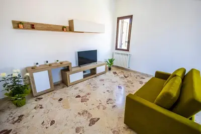 a living room with a green couch and a television at Casa Cloe Mondello in Palermo