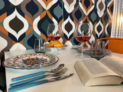 a table with glasses of wine and an open book at Casamori 3- nel cuore del mercato Ballarò in Palermo