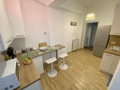 a kitchen with a counter and two white stools at La Casa di Baloo in Palermo
