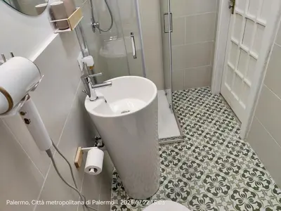 a bathroom with a sink and a toilet and a mirror at Maskan Palermo centro in Palermo