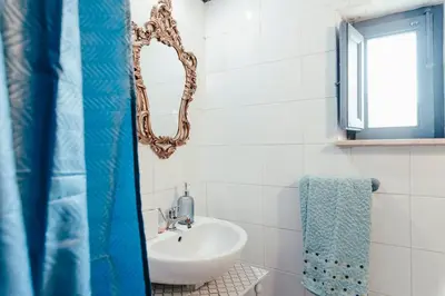 a white bathroom with a sink and a mirror at Nuccia's home vacanze in natura in Ficarazzi