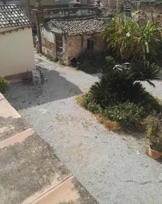 an empty yard with plants and a building at Villetta Casaurro in Bagheria