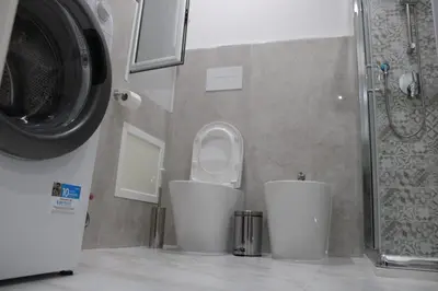 a bathroom with a toilet and a washing machine at Agadir Apartment in Palermo
