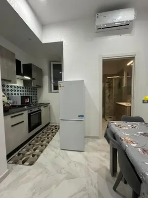 a kitchen with a white refrigerator and a table at Agadir Apartment in Palermo