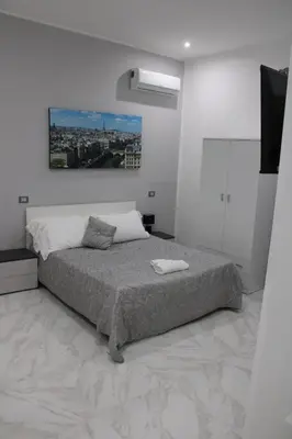 a bedroom with a bed with a painting on the wall at Agadir Apartment in Palermo
