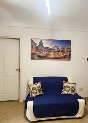 a bedroom with a blue bed with a painting on the wall at Shama APARTMENTS in Palermo