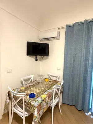 a dining room table with two chairs and a tv on the wall at Shama APARTMENTS in Palermo