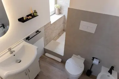 a bathroom with a white sink and a toilet at Gravina 75 Rooms in Palermo