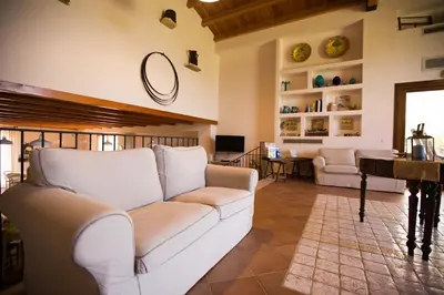 a living room with a white couch and a piano at Casale La Macina - Hotel, Scopello in Scopello
