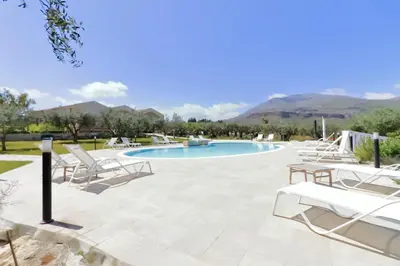 a patio with chairs and a swimming pool at Casale La Macina - Hotel, Scopello in Scopello