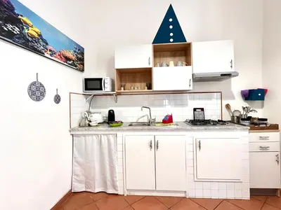 a kitchen with white cabinets and a christmas tree on the wall at La Loggia del Capo in Palermo