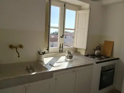 a kitchen with a counter top with a window at Rooftop Magione in Palermo