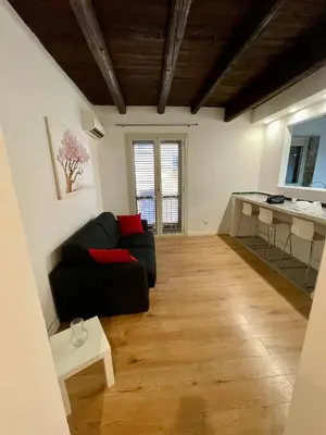 a living room with a black couch and a table at Vicolo Morici in Palermo