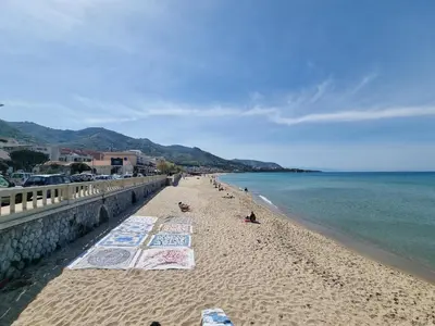 a beach with umbrellas on the sand and the water at Respiro di Mare by Holiday World in Buonfornello