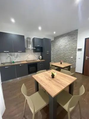 a kitchen with a wooden table and chairs at Palermo Flowers Suites in Palermo