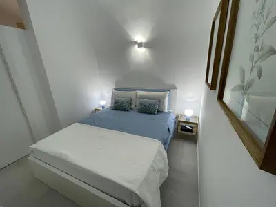 a small bedroom with a bed with blue sheets and pillows at Anfrasipe apartment in Terrasini