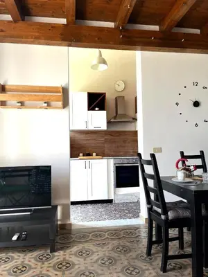 a kitchen with a table and a clock on the wall at Malfitano View in Palermo