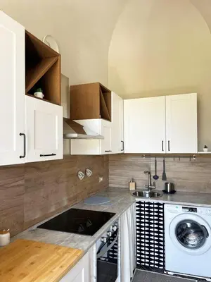 a kitchen with white cabinets and a washing machine at Malfitano View in Palermo