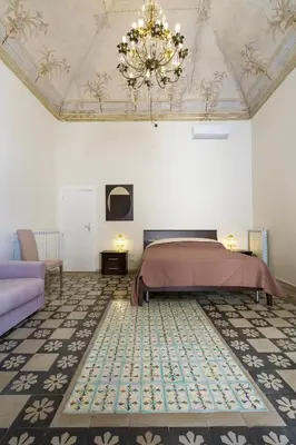 a bedroom with a bed and a chandelier at B&B del Massimo in Palermo