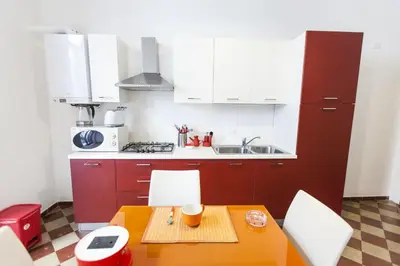 a kitchen with red cabinets and a table and chairs at B&B del Massimo in Palermo