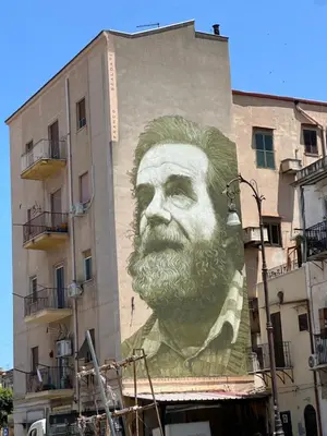 a mural of a man with a beard on the side of a building at A Little Modern House in Palermo