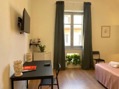 a room with a desk and a bed and a window at La casa di Didì in Palermo