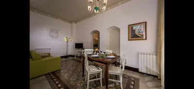 a dining room with a table and a green couch at Borgo la Madrice in Castellammare del Golfo