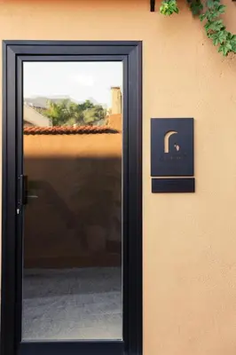 a black door with a picture on a wall at Almarìa - Le case del Castello - San Nicola L'Arena - Trabia in Trabia