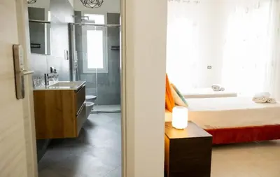 a bedroom with a bed and a bathroom with a sink at B&B Terre del cretto in Nuova Gibellina