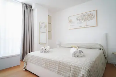 a white bedroom with a bed with towels on it at Encanto Apartment in Palermo