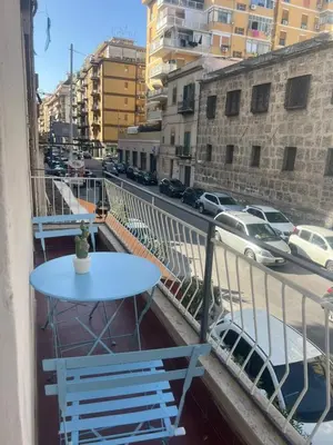 a table on a balcony with a view of a street at Home Sampolo in Palermo