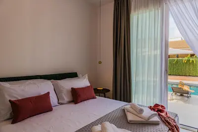 a bedroom with a bed and a large window at NAHIA Collection Villa in Campofelice di Roccella