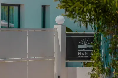 a white fence with a sign in front of a building at NAHIA Collection Villa in Campofelice di Roccella