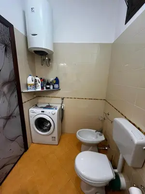 a bathroom with a toilet and a washing machine at Dimora del Moro in Castellammare del Golfo