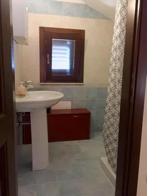 a bathroom with a white sink and a window at Casa Vacanze Soleado house Trabia PA, Sicily in Mandra Capreria